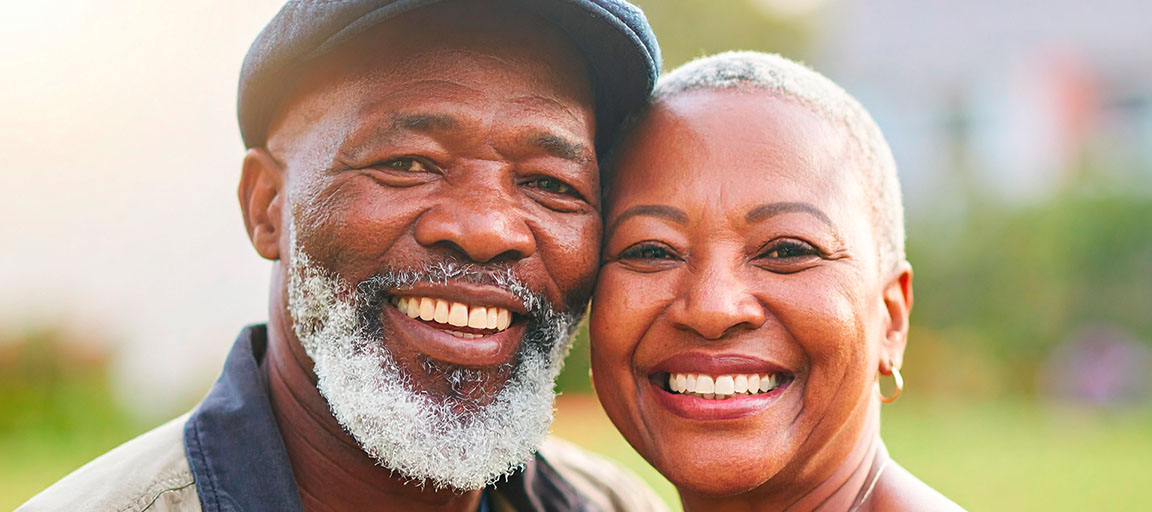 Elder couple smiling in a portrait, side by side